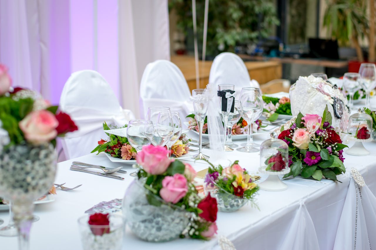 about-us-02 Beautifully decorated wedding table setting with floral arrangements and wine glasses, creating an elegant atmosphere.